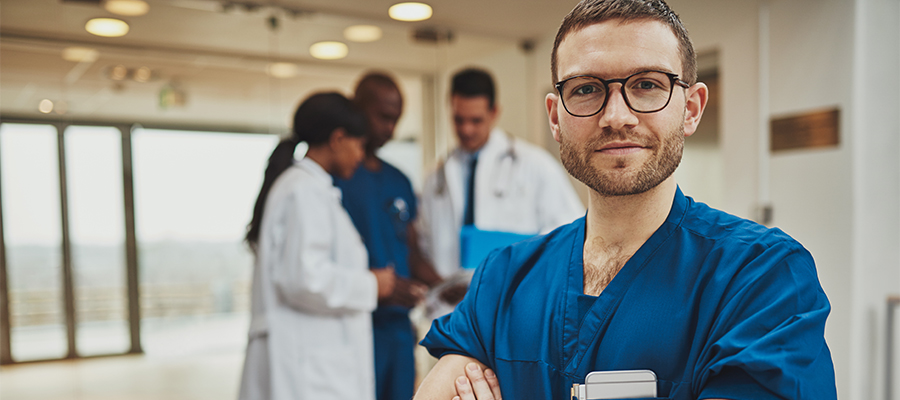 Confident relaxed surgeon doctor at hospital with team of doctors in background